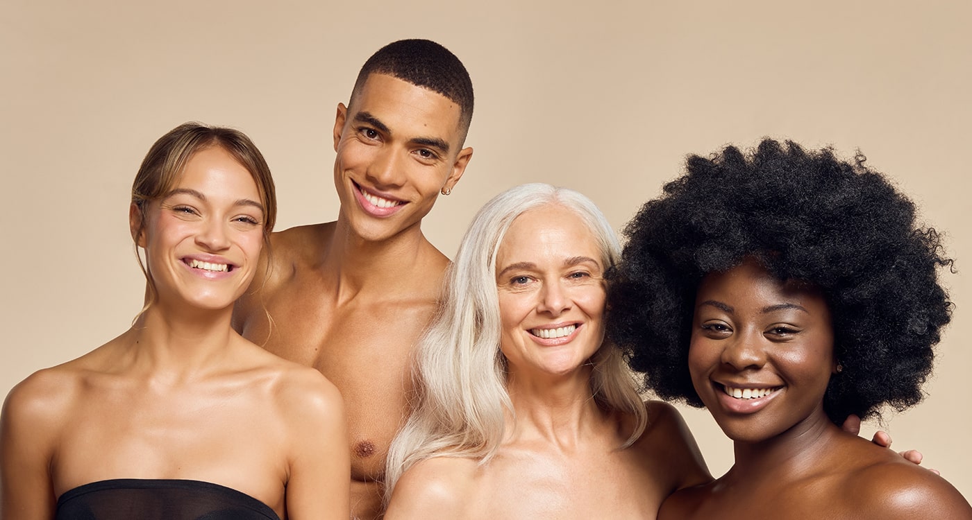 A diverse group of models with various skin types and tones smiling and showing off their radiant, glowing skin achieved with James Read's Self Glow fake tan products.
