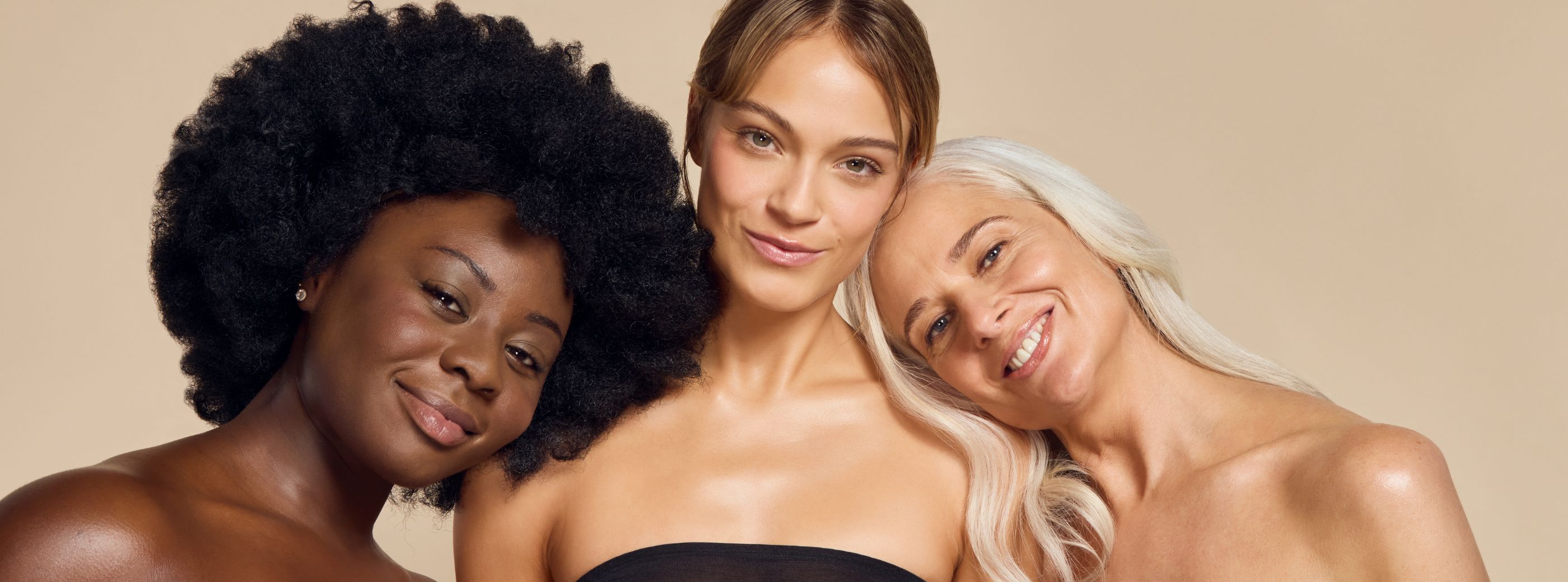 Diverse, glowing women with flawless, bronzed skin achieved using James Read Self Glow sunless tan for a radiant, natural tan and suitable for all skin tones. 