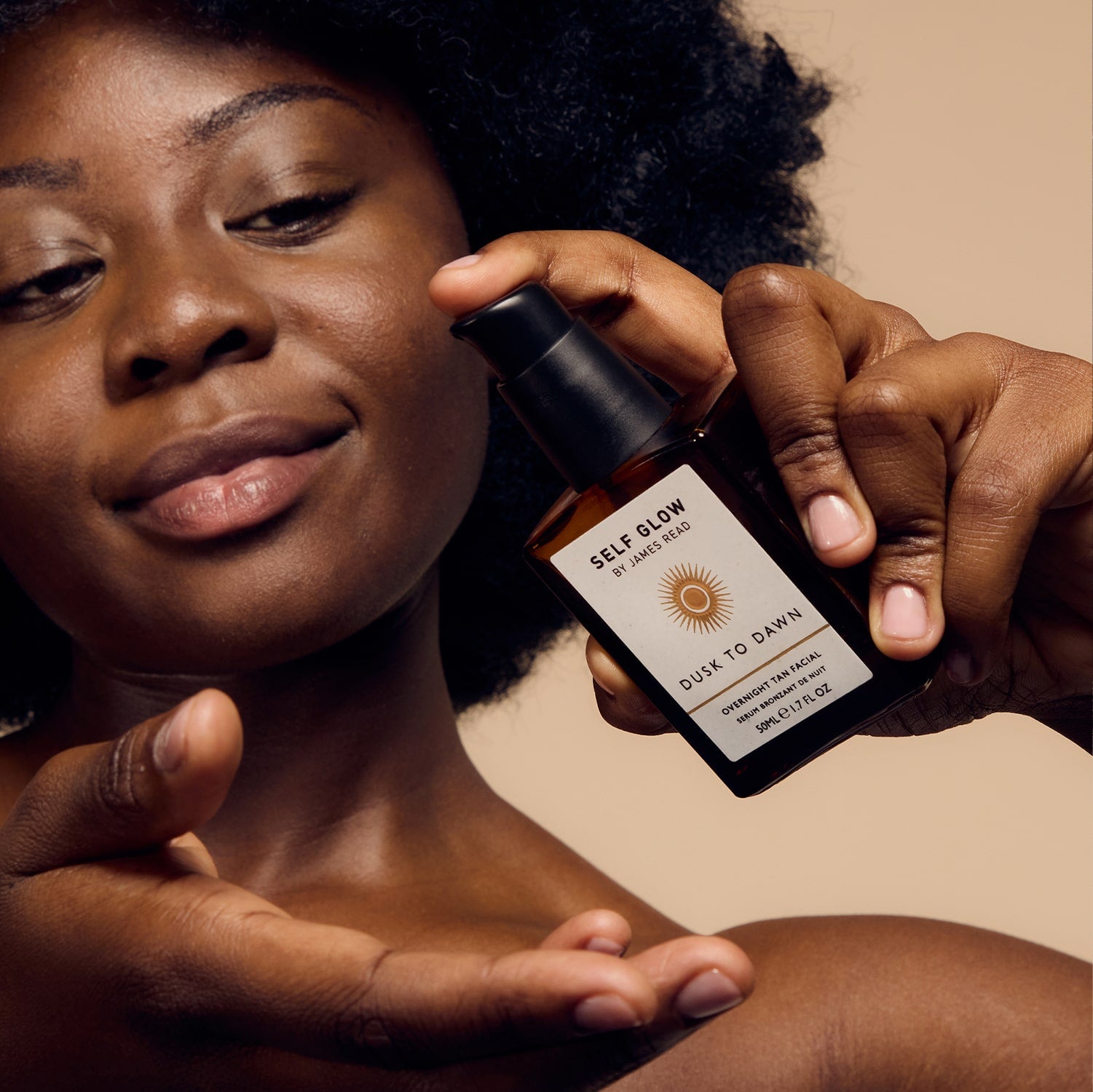 Black female model applying James Read Self Glow sunless tanning skincare product called dusk to dawn overnight tan facial for a flawless, long-lasting glow.