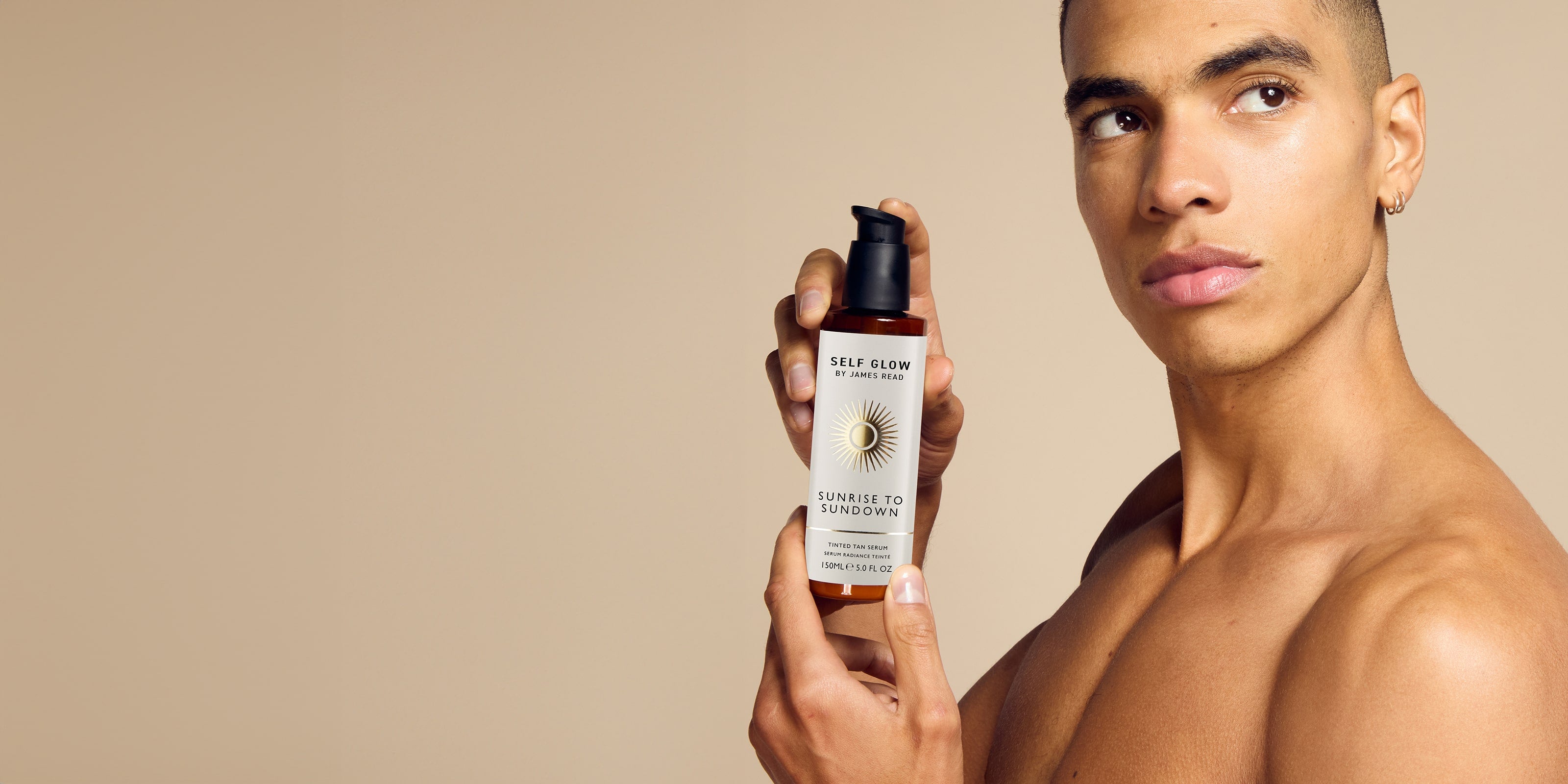 A close-up image of a black male model holding Sunrise to Sundown body fake tan product, known for its soothing and moisturising properties.